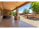 Inviting backyard with covered patio, desert landscaping, and a charming wooden bridge at 42709 W King Fisher Dr, Maricopa, AZ 85138