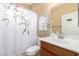Well-lit bathroom with a white vanity, toilet, and decorative shower curtain at 42709 W King Fisher Dr, Maricopa, AZ 85138