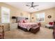Cozy bedroom with neutral walls, carpet, shutters, a ceiling fan, and decorative accents at 42709 W King Fisher Dr, Maricopa, AZ 85138