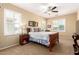 Comfortable bedroom features a wood bed, neutral walls, shutters, and a ceiling fan at 42709 W King Fisher Dr, Maricopa, AZ 85138