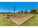 Bocce ball court featuring well-maintained turf and seating area with clear blue skies in the background at 42709 W King Fisher Dr, Maricopa, AZ 85138