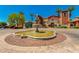 Beautiful water fountain surrounded by a circular driveway and multi-colored buildings on a sunny day at 42709 W King Fisher Dr, Maricopa, AZ 85138