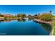 Scenic pond surrounded by vibrant orange flowers, lush greenery, and trees under a clear blue sky at 42709 W King Fisher Dr, Maricopa, AZ 85138