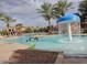 Community pool with a mushroom-shaped water fountain and palm trees at 42709 W King Fisher Dr, Maricopa, AZ 85138