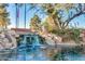 Scenic community water feature with a charming waterfall, lush landscaping, and serene pond at 42709 W King Fisher Dr, Maricopa, AZ 85138