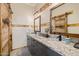 Modern bathroom featuring double sinks with granite countertops and rustic wood framed mirrors at 4297 S Pony Rider Trl, Gold Canyon, AZ 85118
