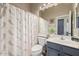 Well-lit bathroom with a shower, patterned curtain, toilet, vanity, and mirror at 4297 S Pony Rider Trl, Gold Canyon, AZ 85118