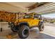 Spacious garage with a yellow jeep, tools, and plenty of storage space at 4297 S Pony Rider Trl, Gold Canyon, AZ 85118