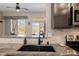 Spacious kitchen featuring granite countertops, dark cabinetry, a stainless steel sink, and convenient access to the patio at 4297 S Pony Rider Trl, Gold Canyon, AZ 85118