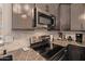 Modern kitchen features stainless steel appliances and stone backsplash, complemented by stylish gray cabinetry at 4297 S Pony Rider Trl, Gold Canyon, AZ 85118