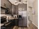 Modern kitchen featuring stainless steel appliances, granite countertops, dark wood cabinets, and stylish light fixtures at 4297 S Pony Rider Trl, Gold Canyon, AZ 85118