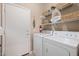 Functional laundry room with a washer, dryer, wire shelving, and storage baskets at 4297 S Pony Rider Trl, Gold Canyon, AZ 85118