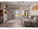 Relaxing living room featuring a comfortable gray sofa, sliding glass doors to the patio, and an accent wall with an American flag at 4297 S Pony Rider Trl, Gold Canyon, AZ 85118