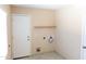 Functional laundry room featuring shelving, white walls, tile flooring, and outdoor access at 4625 W Thomas Rd # 50, Phoenix, AZ 85031