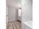 Bathroom with tub shower, white and gray marble tile surround, and white cabinets at 5303 N 7Th St # 326, Phoenix, AZ 85014