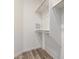 A bright, small, walk-in closet with wood-style flooring and wooden rods ready for organizing clothes at 5303 N 7Th St # 326, Phoenix, AZ 85014