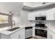 Bright kitchen features white cabinets, stainless steel appliances, and a modern sink with white countertops at 5303 N 7Th St # 326, Phoenix, AZ 85014