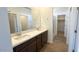 Well-lit bathroom showcasing a double sink vanity with dark brown cabinets, plus a glass shower in the background at 5669 S 253Rd Ave, Buckeye, AZ 85326