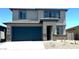 Two-story home featuring a two-car garage, neutral stucco exterior, and a covered front entryway at 5669 S 253Rd Ave, Buckeye, AZ 85326