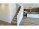 Open-concept staircase leading to a modern kitchen with stainless steel appliances and tiled backsplash at 5669 S 253Rd Ave, Buckeye, AZ 85326