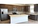 Modern kitchen boasts stainless steel appliances, granite countertops, and dark cabinets with tiled backsplash at 5669 S 253Rd Ave, Buckeye, AZ 85326