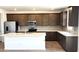 Modern kitchen boasts stainless steel appliances, granite countertops, and dark cabinets with tiled backsplash at 5669 S 253Rd Ave, Buckeye, AZ 85326