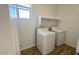 Bright laundry room with modern washer, dryer, and built-in shelving for storage at 5669 S 253Rd Ave, Buckeye, AZ 85326