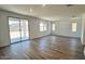 Spacious living room featuring hardwood flooring, large windows, and sliding glass doors to outdoor patio at 5669 S 253Rd Ave, Buckeye, AZ 85326