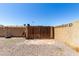Enclosed backyard with tall cinder block wall and gated entrance, offering privacy and security at 617 E Calle Adobe Ln, Goodyear, AZ 85338