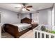 Bedroom with decorative wood headboard, tile floors and ceiling fan at 617 E Calle Adobe Ln, Goodyear, AZ 85338