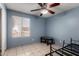 Bedroom with a window, blue walls, tile flooring and ceiling fan at 617 E Calle Adobe Ln, Goodyear, AZ 85338