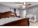 Bedroom with a carved wood bed frame, tile floors, and a baby crib at 617 E Calle Adobe Ln, Goodyear, AZ 85338