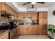 A closer look at the kitchen with wooden cabinets, mosaic tile backsplash, and stainless steel appliances at 617 E Calle Adobe Ln, Goodyear, AZ 85338