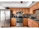 Kitchen featuring stainless steel appliances, wooden cabinets, and tile backsplash at 617 E Calle Adobe Ln, Goodyear, AZ 85338