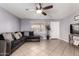 Spacious living room featuring tile floors, a ceiling fan, and a comfortable sofa at 617 E Calle Adobe Ln, Goodyear, AZ 85338