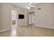 Open bedroom with tile floor, tv, and arched entry to bathroom at 625 W Douglas Ave, Gilbert, AZ 85233