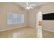 Large primary bedroom with ceiling fan, tile flooring, shutters and ensuite bathroom at 625 W Douglas Ave, Gilbert, AZ 85233