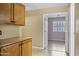 Hallway with wood cabinets leading into a room with window with plantation shutters at 625 W Douglas Ave, Gilbert, AZ 85233