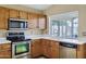 Traditional kitchen features wooden cabinets, stainless steel appliances and a window over the sink at 625 W Douglas Ave, Gilbert, AZ 85233