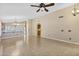 Spacious living area featuring tile floors, ceiling fan, and arched doorway to additional rooms at 625 W Douglas Ave, Gilbert, AZ 85233