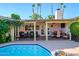 Back patio and pool area featuring comfortable seating, dining area, and well-manicured landscaping at 6255 E Crocus Dr, Scottsdale, AZ 85254