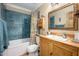 Charming bathroom with wood vanity, blue tiled shower, and vintage details at 6255 E Crocus Dr, Scottsdale, AZ 85254