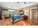 Inviting bedroom with terra cotta floors, iron bed frame, and warm natural light at 6255 E Crocus Dr, Scottsdale, AZ 85254