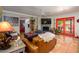 Comfortable living room with tiled floors, ceiling fan, fireplace and bright red french doors at 6255 E Crocus Dr, Scottsdale, AZ 85254
