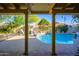 Inviting backyard pool with patio, columns, lush landscaping, and stylish outdoor furniture at 6255 E Crocus Dr, Scottsdale, AZ 85254