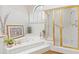 Well-lit bathroom with jacuzzi tub, shuttered window, and gold-trimmed shower with glass doors at 7525 E Gainey Ranch Rd # 164, Scottsdale, AZ 85258
