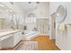 Bright bathroom featuring a vanity, walk-in shower, hardwood floors, and large mirror at 7525 E Gainey Ranch Rd # 164, Scottsdale, AZ 85258