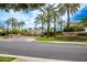 Welcoming community entrance with lush palm trees and a beautifully landscaped median at 7525 E Gainey Ranch Rd # 164, Scottsdale, AZ 85258