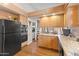 Eat-in kitchen with granite countertops, light wood cabinetry, and black appliances at 7525 E Gainey Ranch Rd # 164, Scottsdale, AZ 85258