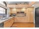 Bright kitchen with granite countertops and light wood cabinetry at 7525 E Gainey Ranch Rd # 164, Scottsdale, AZ 85258